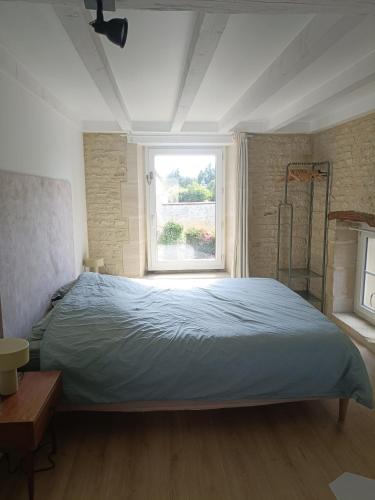 une chambre avec un grand lit et une fenêtre dans l'établissement LE SEIZE - Gîte 4 personnes - entre Caen et la mer, à Cairon