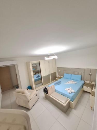 a bedroom with a bed and a chair and a mirror at Marina Front Marassi chalet in Al Wiḩdah
