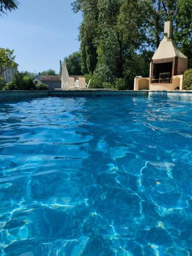 a swimming pool with blue water in front of a gazebo at Chez Pierre Et Deme in Saint-Jacques-des-Guérêts