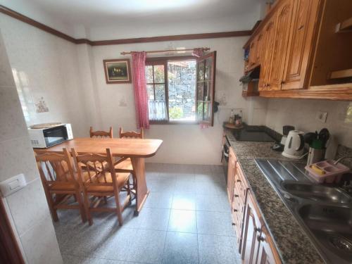 a small kitchen with a wooden table and chairs at Twin Room at Villa Lila in Puerto de la Cruz