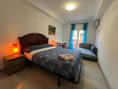 Un dormitorio con una cama y una mesa con una lámpara. en ZARAGOZA CENTRAL APARTMENT, en Zaragoza