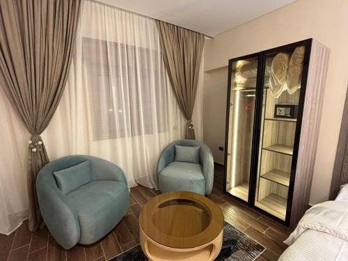 a room with two chairs and a table and a bed at Gold Palace Hotel in Cairo