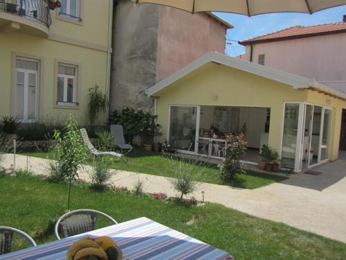 a teddy bear sitting on a table in front of a house at Aurelia Rooms in Mostar