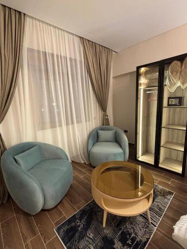 a living room with two chairs and a coffee table at Gold Palace Hotel in Cairo