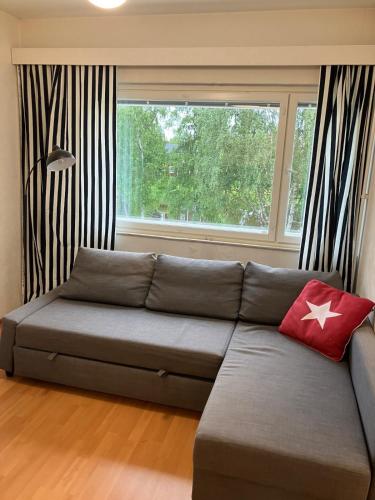 a gray couch in a living room with a window at Apartment in the center of Lapua in Lapua