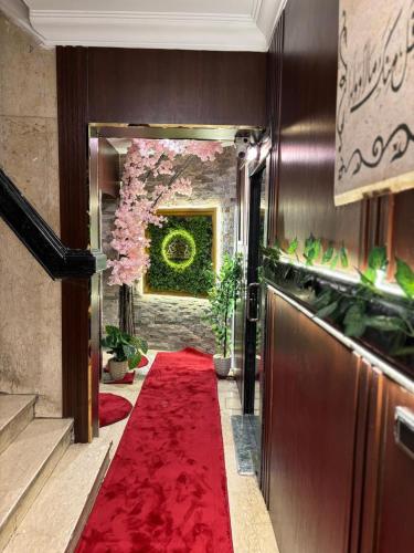 a hallway with a red carpet and a plant at Gold Palace Hotel in Cairo