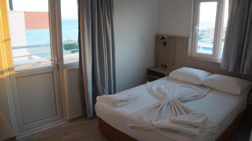 a small bedroom with a bed with a window at Hotel Marine in Ayvalık