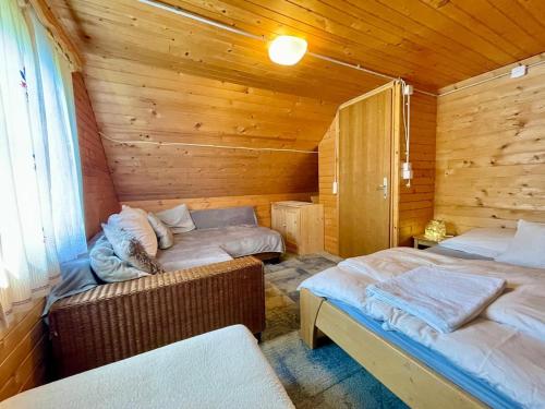 a bedroom with two beds in a wooden cabin at Vacation cottage house Enya in Koprivnik v Bohinju