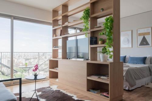 Una sala de estar con una gran estantería de madera. en MOT Azopardo 700 'A' - Lux Lofts Puerto Madero, en Buenos Aires