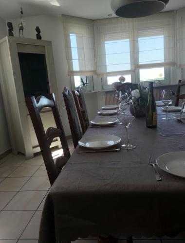 - une table à manger avec des assiettes et des verres à vin dans l'établissement Chez Jeanine Maison Familiale, à Schaeffersheim