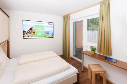 a hotel room with a bed and a window at Landhaus Anni in Saalbach-Hinterglemm