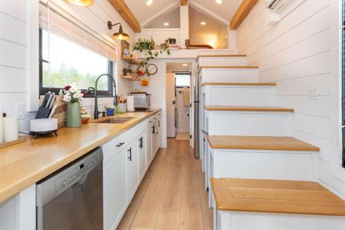 a kitchen with white cabinets and wooden countertops at H&N Tiny Home in Juno