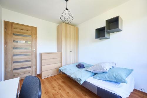 a bedroom with a bed and a tv on the wall at Korczak Centrum Olsztyn in Olsztyn