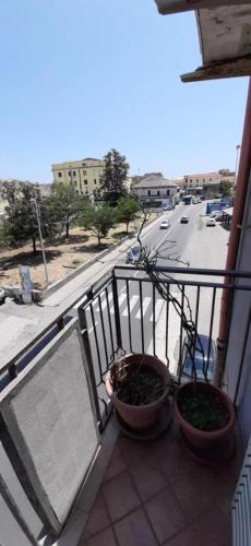 a balcony with two potted plants on a balcony at International Apartment in Catanzaro Lido