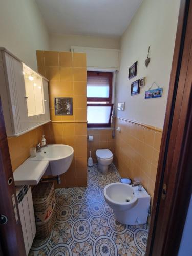 a bathroom with two sinks and a toilet at Villa Emilia Mondello Appartamento Emily con vista sul mare in Palermo