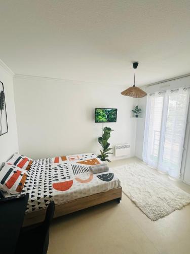 Un dormitorio con una cama en una habitación blanca. en Lumineux & cosy studio, en Poitiers