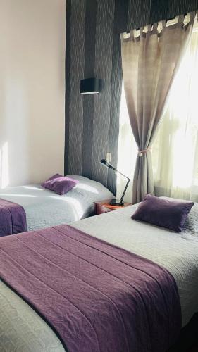 a hotel room with two beds and a window at La Blanca Hotel in Viña del Mar
