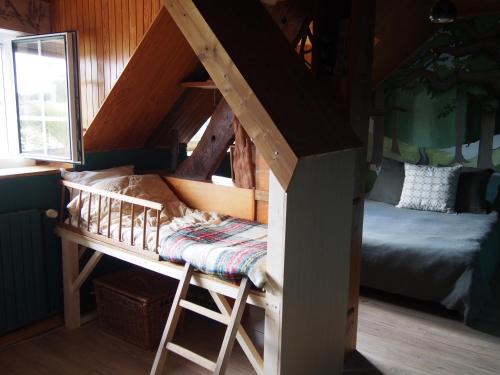 a bunk bed in a room with a bed and a window at La Sorcière et le Korrigan in Paimpont