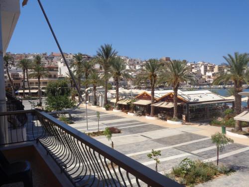 a balcony of a building with palm trees and a street at SeaShell apartment Sea View, Castle View 200metres from the Beach in Sitia