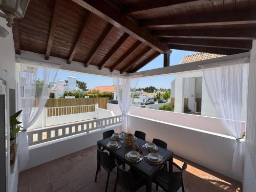 un patio avec une table et des chaises sur un balcon dans l'établissement Sanbia - Comporta Beach House, à Carvalhal