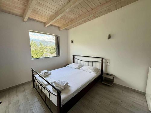 a bedroom with a large bed with a window at Pashaj Himare Guest House in Himare