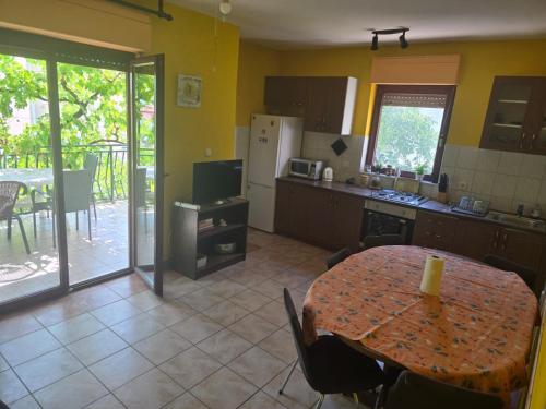 a kitchen with a table and a kitchen with a table and chairs at Rajčić Apartmani in Omiš