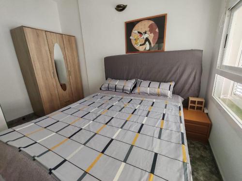 a bedroom with a bed with a gray and yellow quilt at Akimaria Residence in Oropesa del Mar