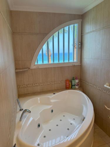 a bath tub in a bathroom with a window at Akimaria Residence in Oropesa del Mar