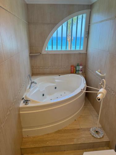 a bath tub in a bathroom with a window at Akimaria Residence in Oropesa del Mar