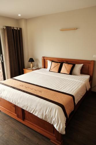 a bedroom with a large bed with white sheets at Moc Hoang Hotel in Hanoi