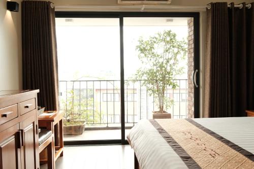 a bedroom with a bed and a large sliding glass door at Moc Hoang Hotel in Hanoi