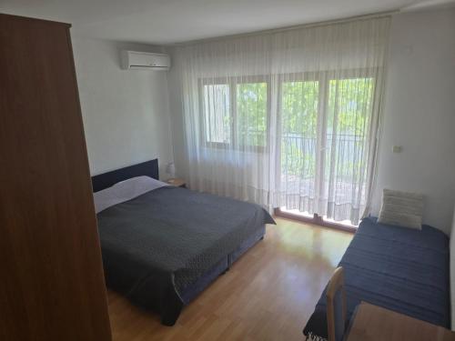 a bedroom with a bed and a window at Rajčić Apartmani in Omiš