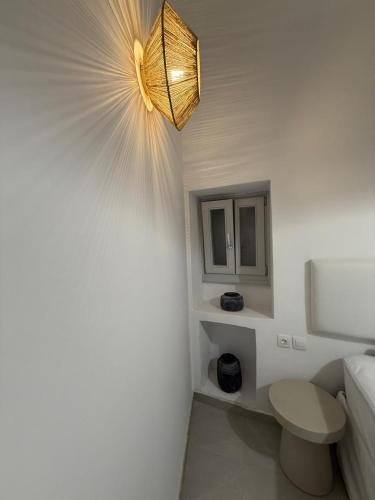 a bathroom with a toilet and a chandelier at Ola House Dryopida Kythnos in Dhriopís