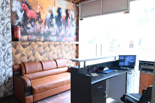 a office with a leather couch and a desk with a computer at Happpy Stay in Lucknow