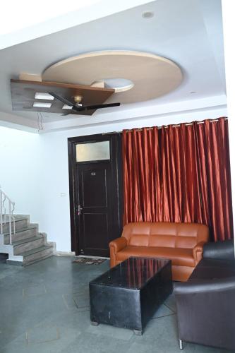 a living room with a couch and a red curtain at Happpy Stay in Lucknow