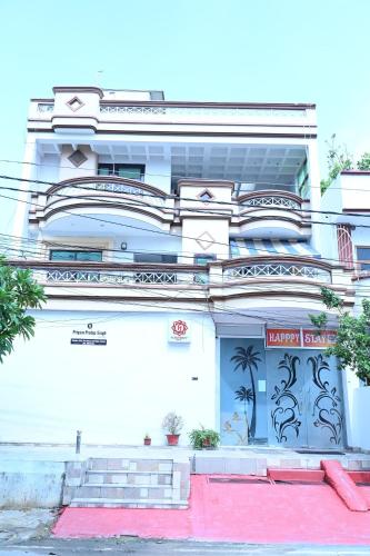 a white building with a sign on it at Happpy Stay in Lucknow