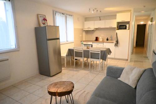 un salon et une cuisine avec un canapé et une table dans l'établissement Appartement, jolie vue montagne, à Seyssel