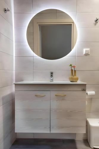 un baño con lavabo y espejo en Paxos In Square (Apartment Amfitriti), en Gáios