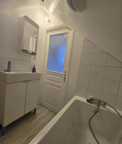 une salle de bain blanche avec une baignoire et un lavabo dans l'établissement Studio cosy proche centre-ville, à Reims