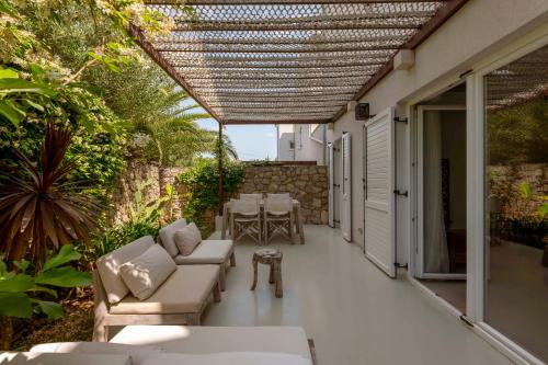 an outdoor patio with couches and a table and chairs at Galboka Residence in Nerezine