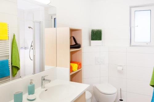 biała łazienka z umywalką i toaletą w obiekcie Landhaus Anni w Saalbach Hinterglemm