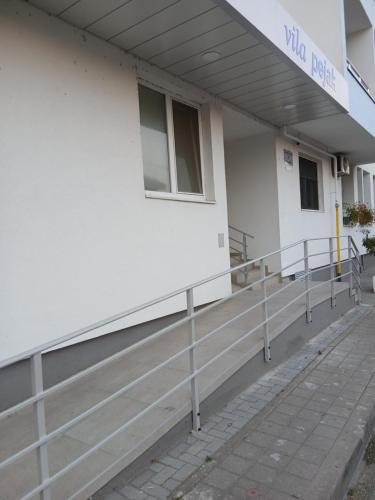a white building with a fence in front of it at Tri srca in Banja Koviljača
