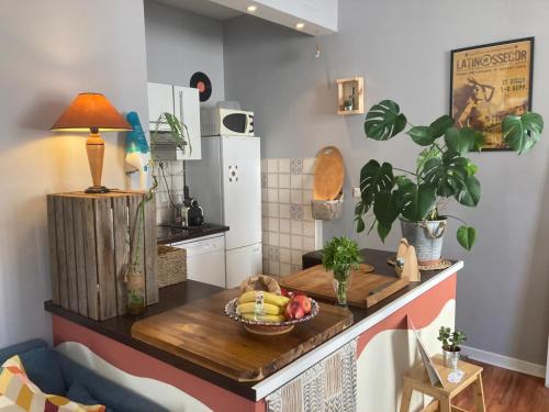 a kitchen with a table with a bowl of fruit on it at Chez Jigé - Bel appartement à côté de l'Adour in Bayonne