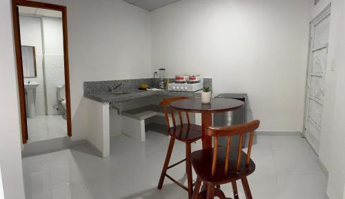 une cuisine avec un comptoir, une table et un tabouret dans l'établissement Shalom, à Huamboya