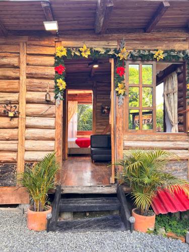 a porch of a wooden cabin with plants and flowers at Cabaña La Martina in Santa Rosa de Cabal