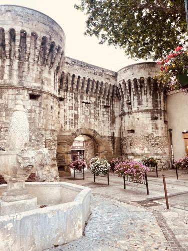 a stone building with a fountain in front of it at B&B Temps Suspendu Provence in Pernes-les-Fontaines
