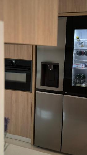a kitchen with a refrigerator and a microwave at ARYVE Boutique Villa mit Akropolis- und Meerblick, Infinity-Pool und Designer-Interieur in Malona Village