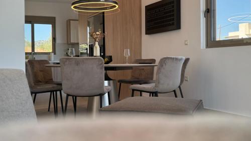 a dining room with a table and chairs at ARYVE Boutique Villa mit Akropolis- und Meerblick, Infinity-Pool und Designer-Interieur in Malona Village