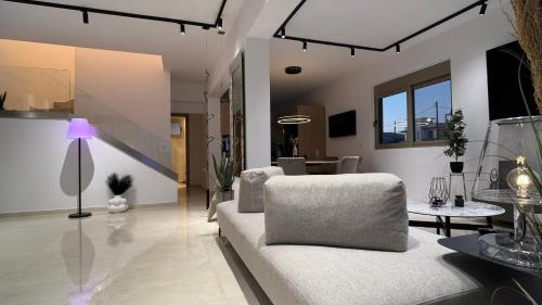 a living room with a couch and a table at ARYVE Boutique Villa mit Akropolis- und Meerblick, Infinity-Pool und Designer-Interieur in Malona Village