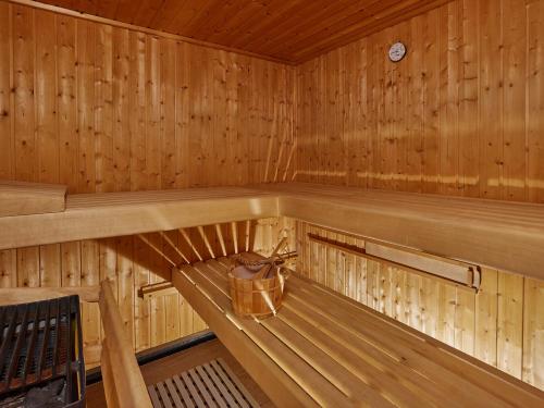 a wooden sauna with a basket on a bench at Appartement Gästehaus Bergkristall in Sölden